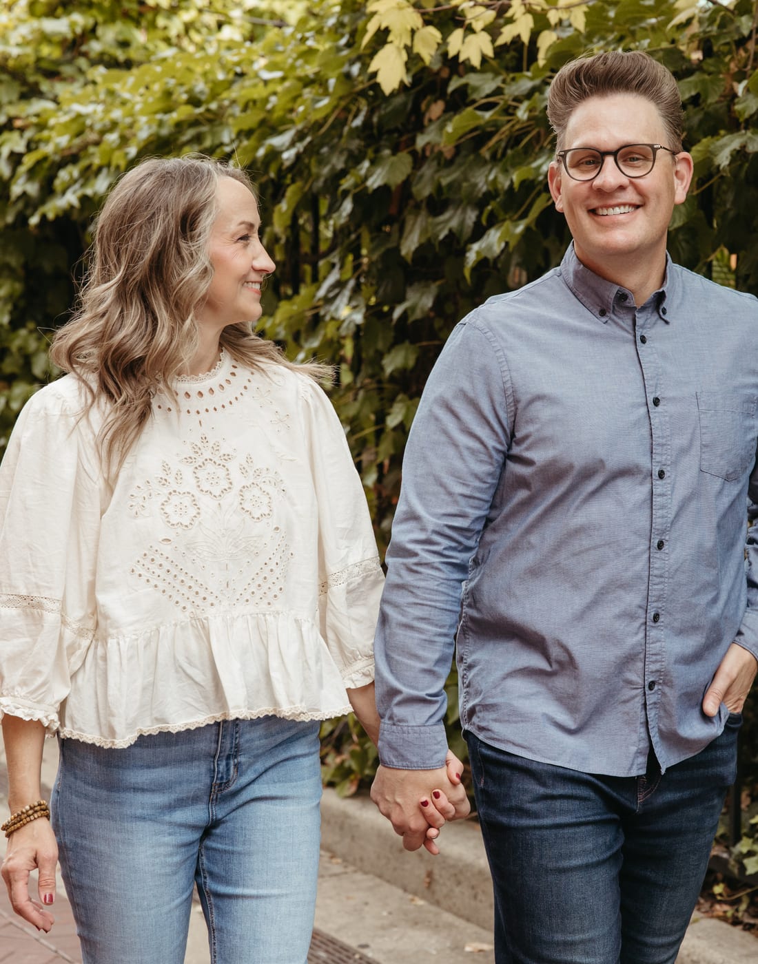 Jason and Jodi Nelson walking hand in hand outdoors.